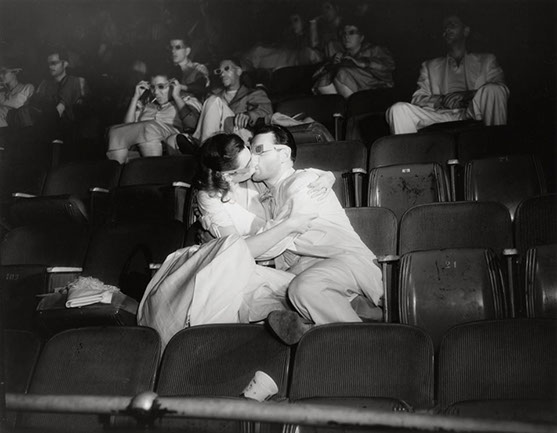 Photo d'un couple s'embrassant dans une salle de cinéma